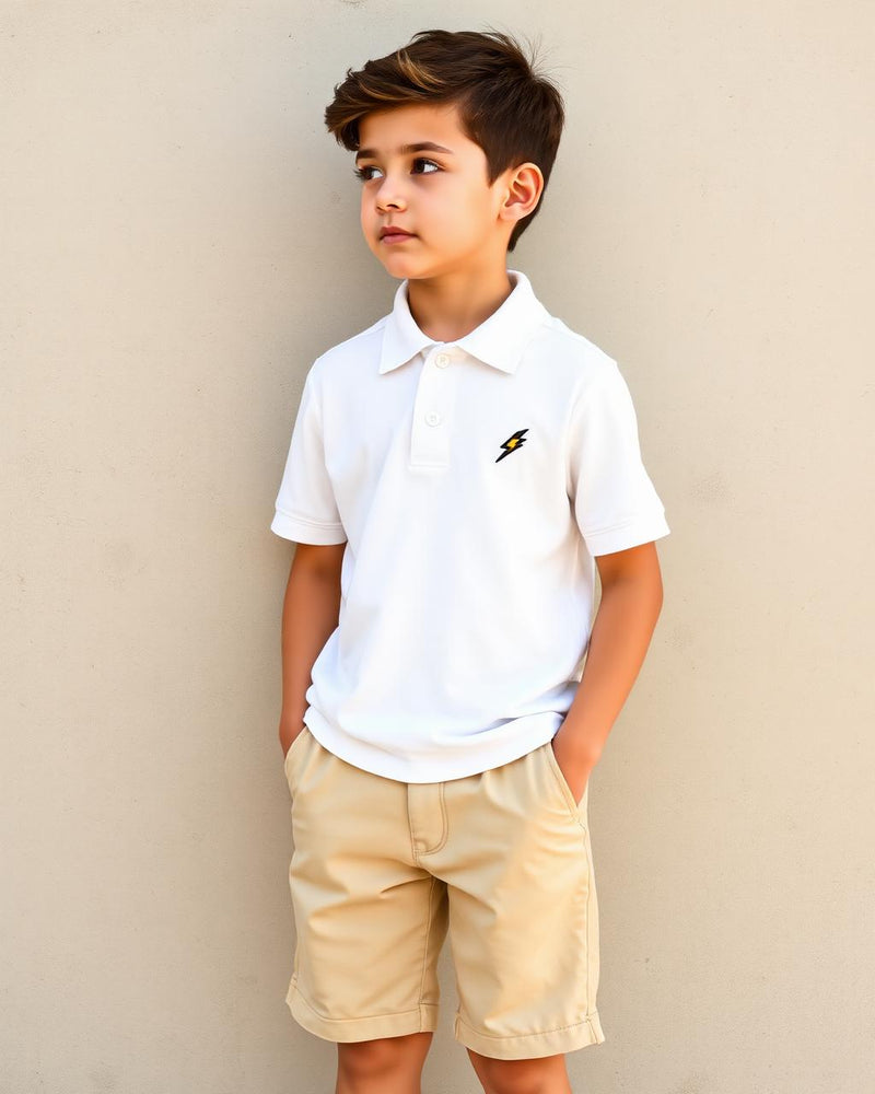 Boy in white Bolt Polo with beige chino shorts on concrete wall